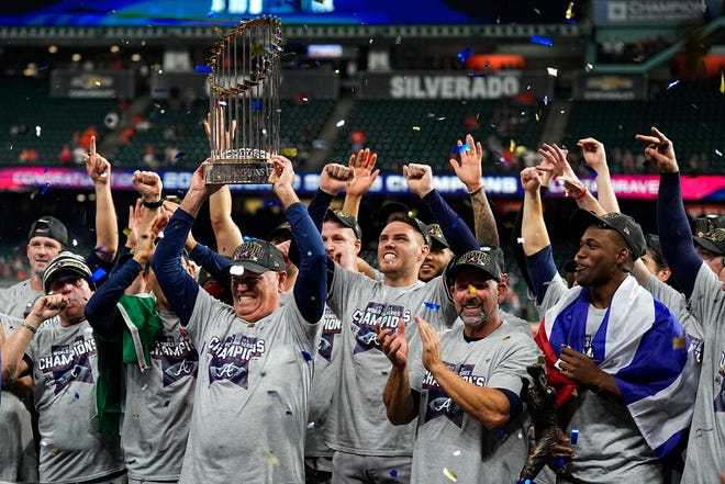 Atlanta Braves coach Brian Snitker holds the up the trophy after winning the world series in game six against the Houston Astros