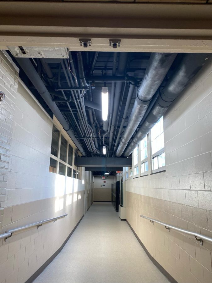 The ceiling in the tech hallway has exposed pipes that were painted black to make them blend in.
