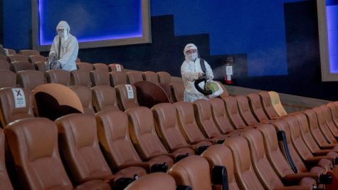 Movie theater staff disinfecting theaters between screenings.