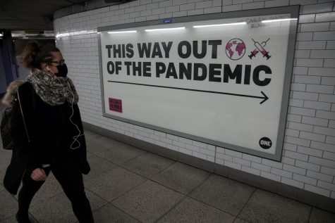 A woman walks by a health poster while walking to Londons Westminster underground train station in England.
