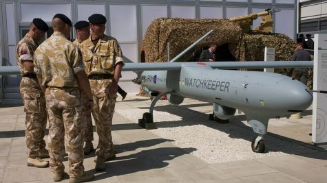  A group of British Army soldiers stand adjacent to a “Watchkeeper” unmanned aerial vehicle (UAV).