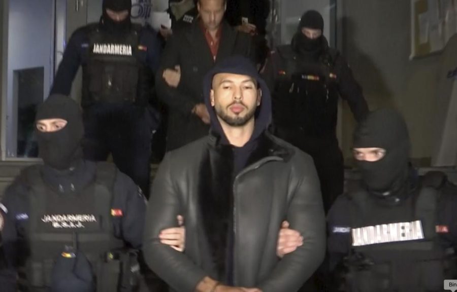 Andrew Tate is escorted to jail by Romanian authorities.