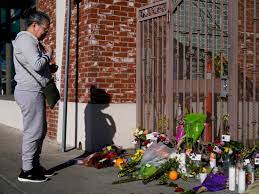 People continue to pay their respects at a makeshift memorial in Half Moon Bay, Calif., following one of three mass shootings in the state.