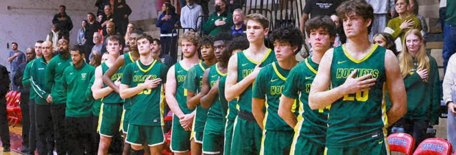 The Damascus Hornets 2022-23 boys basketball team standing for the national anthem prior to their away game against Wootton.