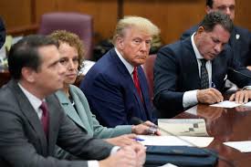 Trump sits among his lawyers in New York where he pleaded not guilty to 34 criminal charges. 