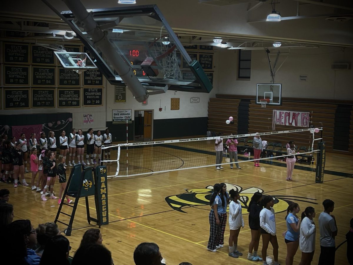 Both Damascus and Clarksburgs players and fans rising for The Star Spangled Banner prior to our Dig Pink themed regular season match.