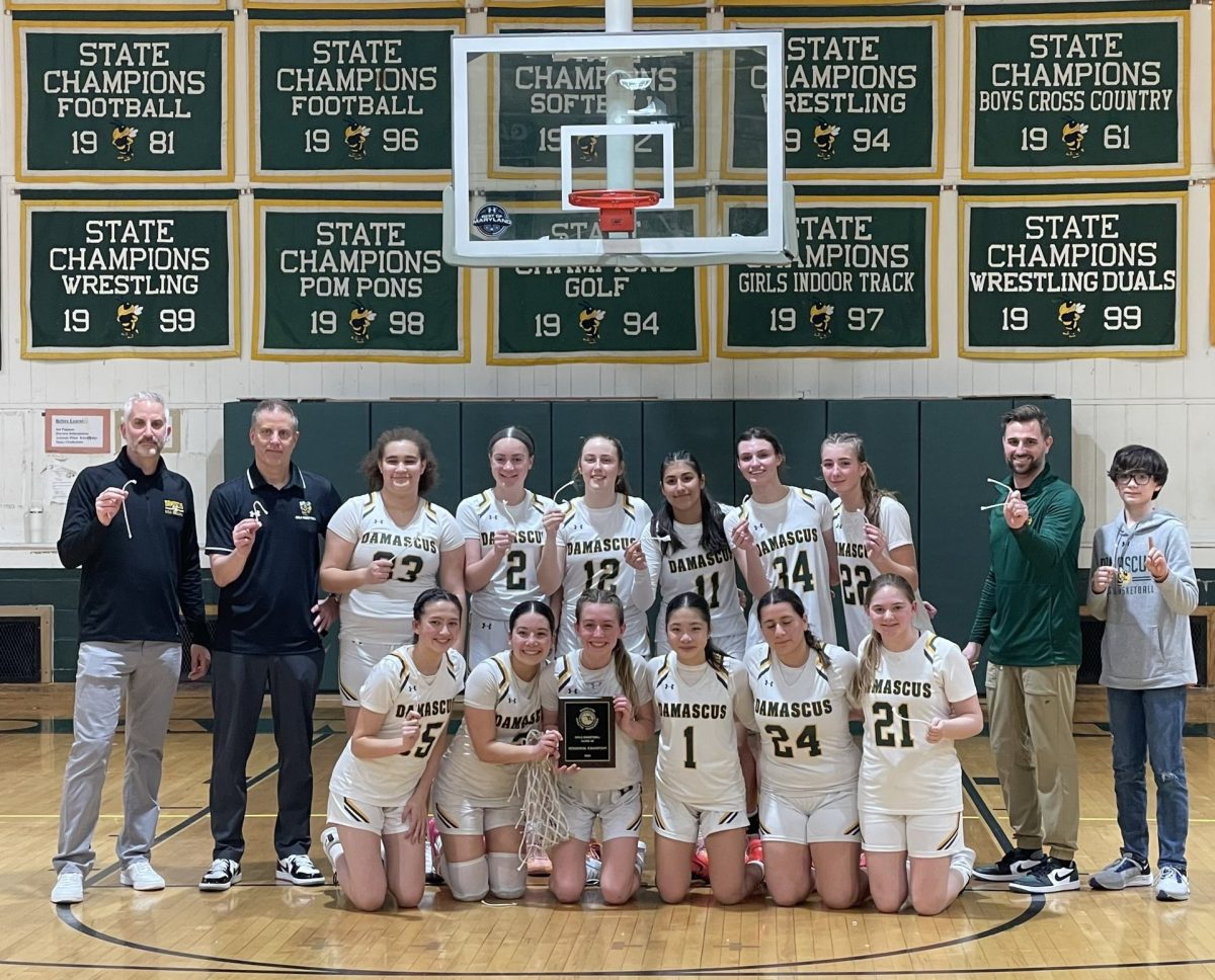 Damascus Girls Varsity Basketball team, coaches, and manager each holding a piece of the net from the 3A Regional Championship game.