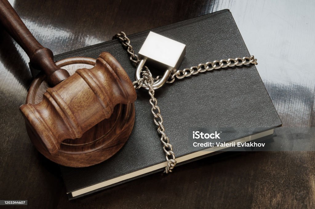 Book with wooden judge gavel, chain and padlock on wooden table, censorship concept, Valerii Evlakhov, stock pictures.
